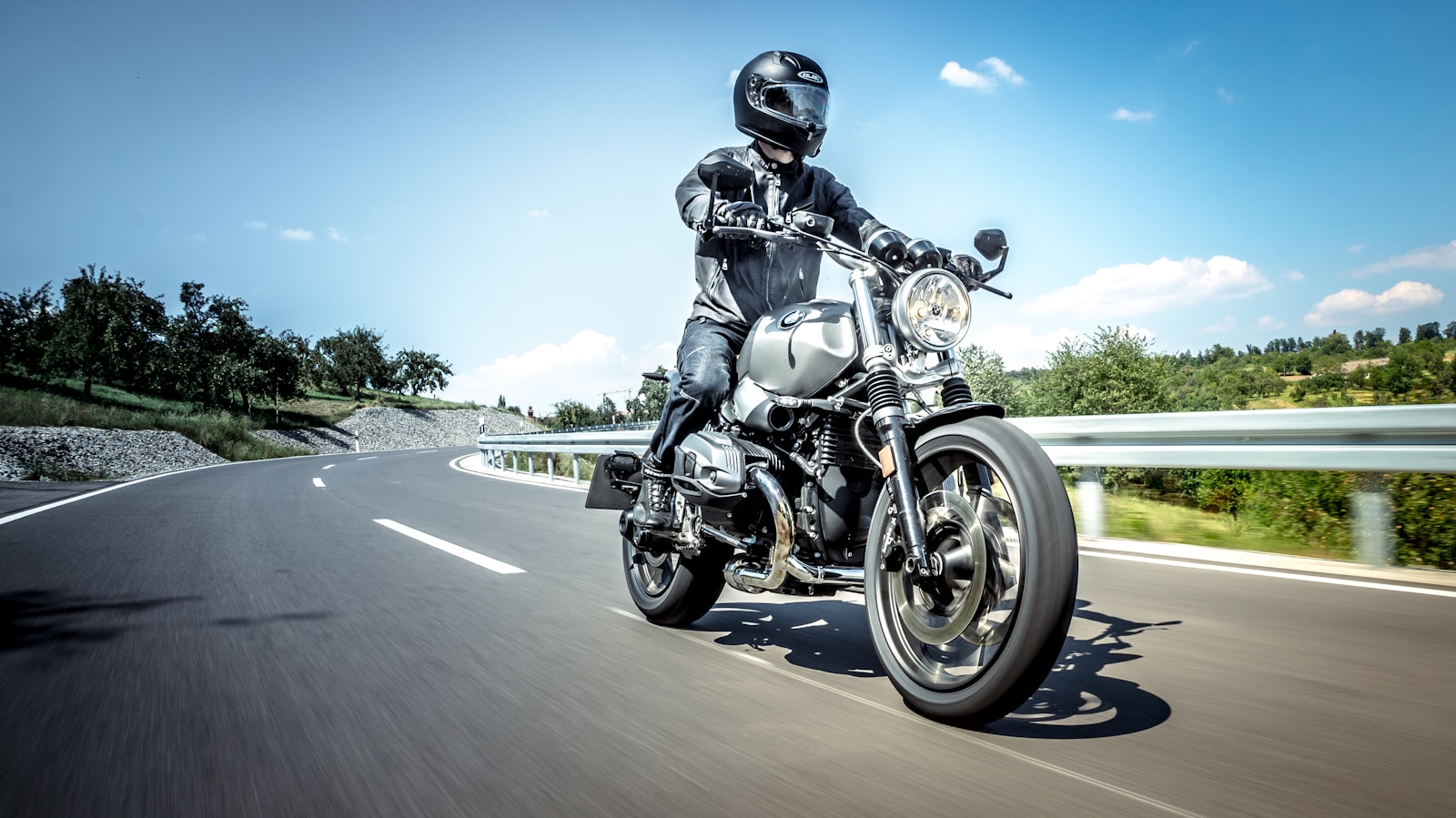 man in black helmet riding on black motorcycle on road during daytime, motorcycle